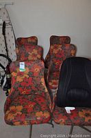 Six retro swivel chairs with floral upholstery, metal swivel legs visible, showing seating and backrest details.