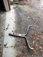 Full view of Corvette Y pipe exhaust on concrete floor with some fallen leaves around.