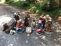 Full set of fiberglass nativity figures arranged on driveway