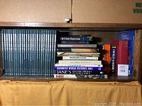 Shelf with a blue boxed set titled Encyclopedia of World War II, various history and military books including Guinness World Records 2001, Jane's Fighting Aircraft of World War II, and others.