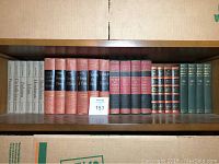Books arranged on a wooden shelf showing various titles including works by HG Wells, Winston Churchill, and religious studies.