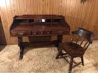 Desk and chair set against wooden paneled wall, showing overall design and finish