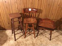 Photo showing the swivel chair, tall stool, and telephone stand against a wood-paneled wall on carpet flooring.