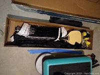 Open box showing folded net, paddles, and balls inside the packaging