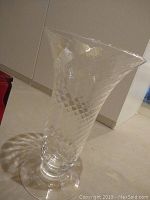 Side view of large clear glass vase with diamond cut pattern