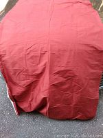 Photo of a red raw silk curtain panel, showing fabric texture and color.