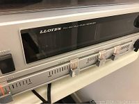 Close-up of the front panel of Lloyd's FM-AM multiplex receiver showcasing the tuning window and slider controls.