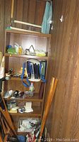 Photo of wooden shelves holding various craft and office supplies including scissors, binding folders, tape dispenser and other tools.