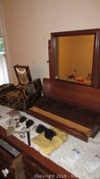Dresser top pivoting mirror on wooden dresser with jewelry box and costume jewelry laid out on table