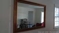 Full view of the rectangular mirror hanging on the wall, showing its size and reflective quality.