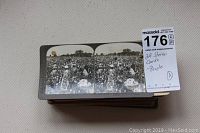 Stack of antique stereo cards showing a crowded outdoor field scene with many people.
