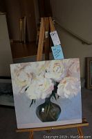 Front view of square canvas on wooden easel showing full composition: white flowers in green vase
