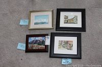 Five original framed paintings arranged on carpet, with notes labeling artists Molly Davis Gough, Carolyn Bradley, Lillian Kennedy.