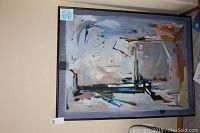 Framed original abstract painting hanging against a beige wall showing full painting with abstract shapes and muted color palette.