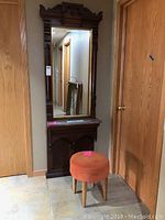 Front view of full pier mirror assembly with marble shelf and vanity stool placed at its base