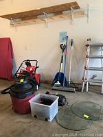 Overview of garage essentials including Shop Vac, brooms, shovel, and glass tabletops.