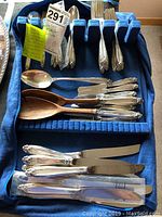 Tray displaying assorted Prelude pattern flatware on blue felt insert