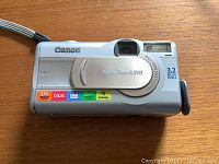 Canon PowerShot A310 digital camera front view showing lens cover and branding.