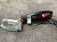 Braun Saphir-jet steam iron and Shark cordless handheld vacuum side by side on carpeted floor.