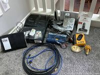 Photo displaying multiple small electronics including Panasonic cordless phones, Sony Walkman, GE clock radio, a walkie music device, and cables