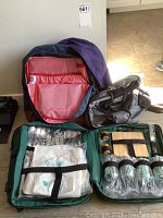 Photo showing picnic backpack opened with organized cutlery, tablecloth, napkins, glasses, cutting board and knife.