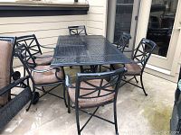 Full set on patio showing table and six chairs with cushions
