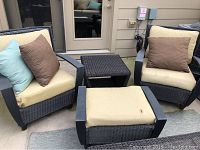 Overview of two wicker chairs, ottoman, side table, cushions and pillows