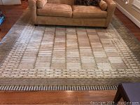 Full view of rug under sofa, showing overall geometric pattern and dimensions.
