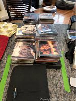 Stack of CDs on a countertop showing multiple albums in original jewel cases