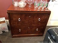 Front view of Thomasville Bogart lateral file cabinet showing two drawers with silver ring pulls and burled wood fronts.