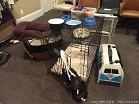 Wide view showing the kennel wire cage, pet carrier, dog bed, dog pen, and other items on the floor.