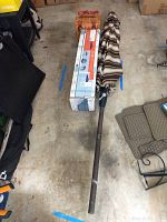 Complete lot including boxed Quest gazebo tent, folded brown and white striped patio umbrella, and wicker picnic basket.