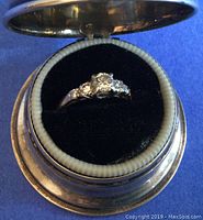 Ring displayed in open velvet-lined Birks case, overhead view.