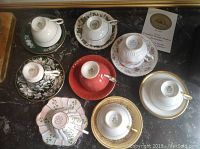 Top view of eight assorted cups and saucers showing different floral and gold trim patterns.