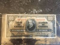 Front of 1937 $100 Bank of Canada note showing portrait, serial number and condition under sleeve