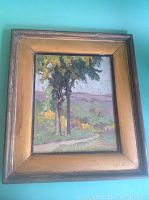 Frontal view of framed oil painting showing two trees, path and hills