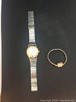 One round watch and one small square watch side by side on black background