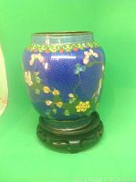 Front and side view of the small round cloisonné vase on wooden stand, showing detailed blue enamel and floral decoration with metal rims.