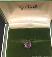 Ring centered in green velvet-lined Juliet box showing top view of amethyst