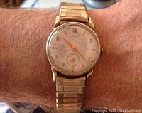 Watch on wrist showing dial, hands, and expansion bracelet