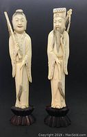 Front view of Emperor and Empress bone carvings on wooden stands