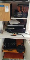 Full view of shelf showing Sony CD player on bottom, speakers on left, and stacks of classical CDs on top shelves.