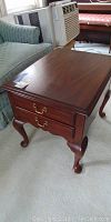 Full view of the hardwood end table showing the polished wood surface and cabriole legs.