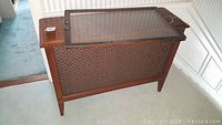 Wood framed hall table with woven detail at front, flat top surface, and showing wear.