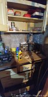 Photo of wooden workbench with Sears Craftsman bench grinder Model 257191100 on left, tool drawers below, multiple hardware and plumbing supply boxes on shelves above and in front of a concrete wall.
