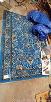 Full view of the rectangular blue Kashan Collection rug laid on the floor showing its vibrant color and design.