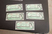 Front side of all five Canadian 1 dollar bills showing Queen Elizabeth II and date 1867-1967 Centennial commemorative design.