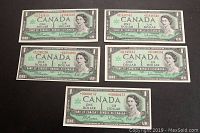 Five sequential Canadian $1 bills from 1967 Centennial series laid out to show front details and numbering.