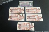 Overview of one $10 and five $2 Canadian banknotes laid out.