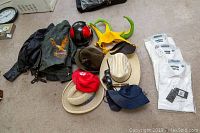 Photo of 3 kids Harley Davidson jackets, various hats including novelty horned hat, cowboy hats, and a helmet on carpet